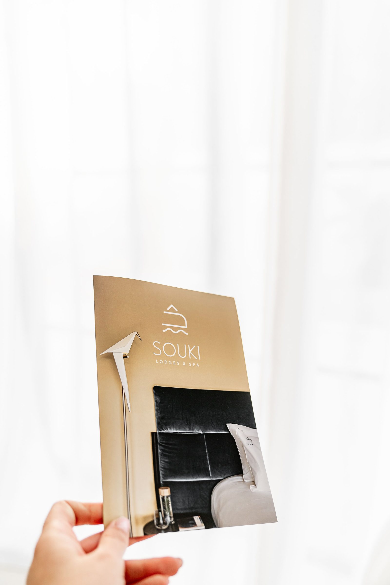 Bon cadeau Souki imprimé et plié en deux, tenu à la main