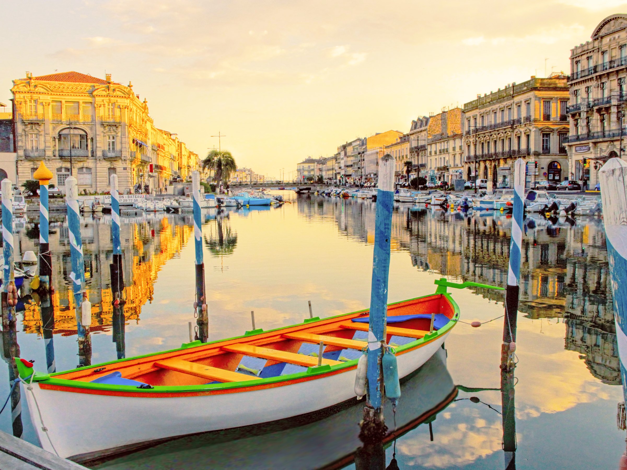 Traditional boats moored in a canal at Sète, in front of the quayside façades