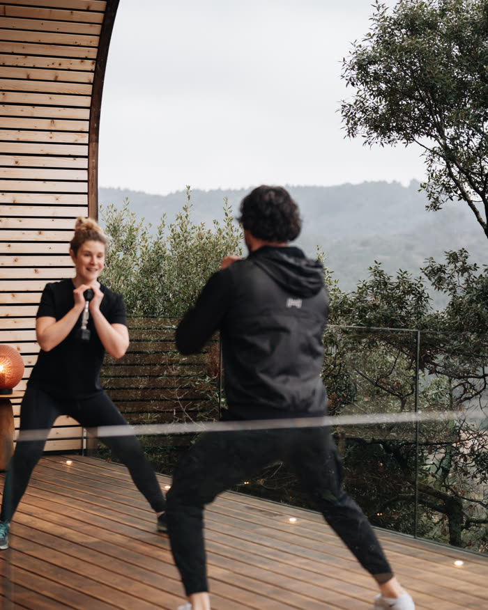 Une séance de coaching sportif sur la terrasse du lodge, face aux collines d’hiver