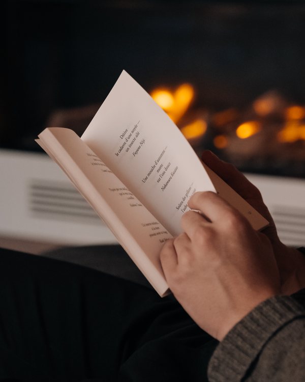 Un livre ouvert tenu devant le feu de la cheminée du salon