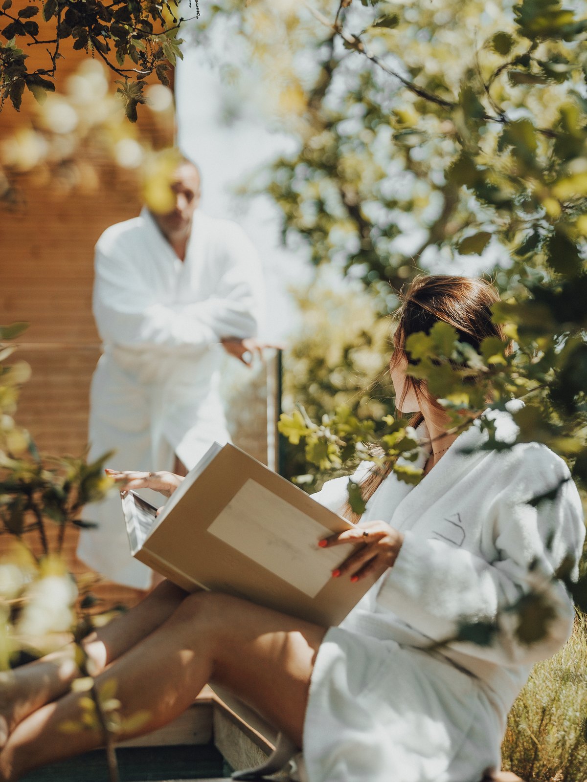 Two travelers in bathrobes reading under the oak trees of the estate, Souki Lodges & Spa (Hérault)