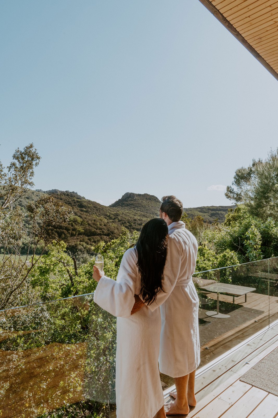 Two travelers in bathrobes facing the hills from the terrace, Souki Lodges & Spa, Cabrières (Hérault)