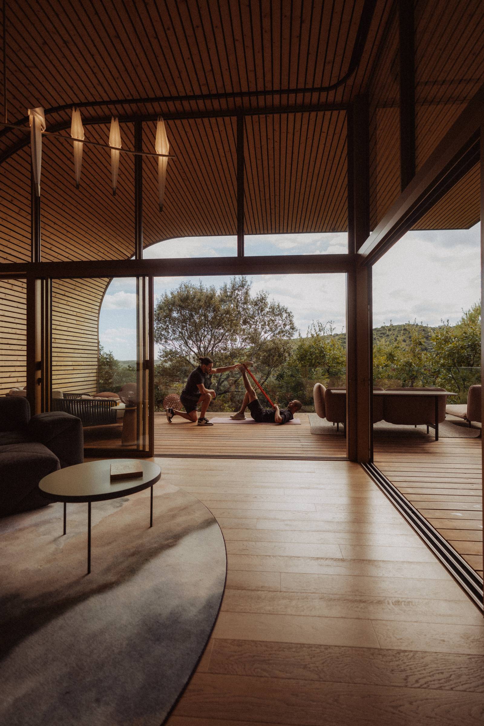 From inside a lodge, a stretching session on the terrace, open to the hills, Cabrières (Hérault)