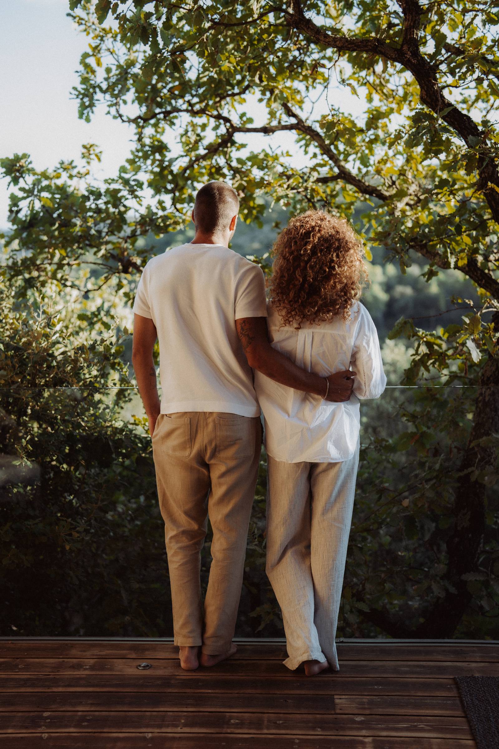 Couple embracing facing the scrubland at dusk, terrace of Souki Lodges & Spa