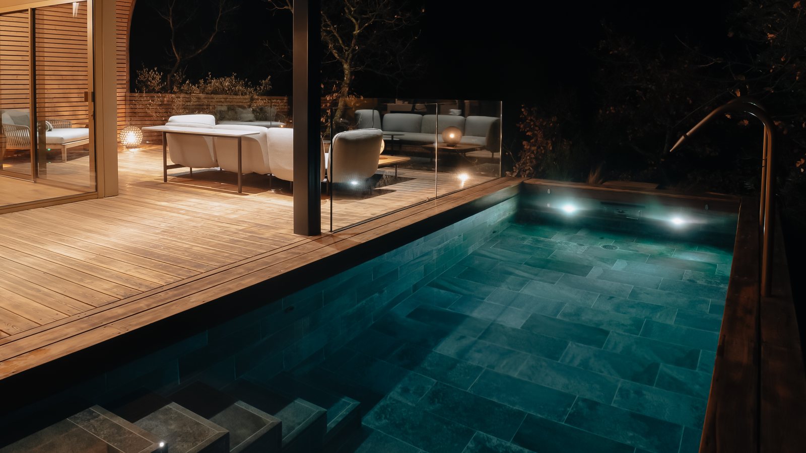 La piscine privée d’un lodge éclairée de nuit, chauffée à 32 °C, sous l’auvent de bois, Souki à Cabrières (Hérault)