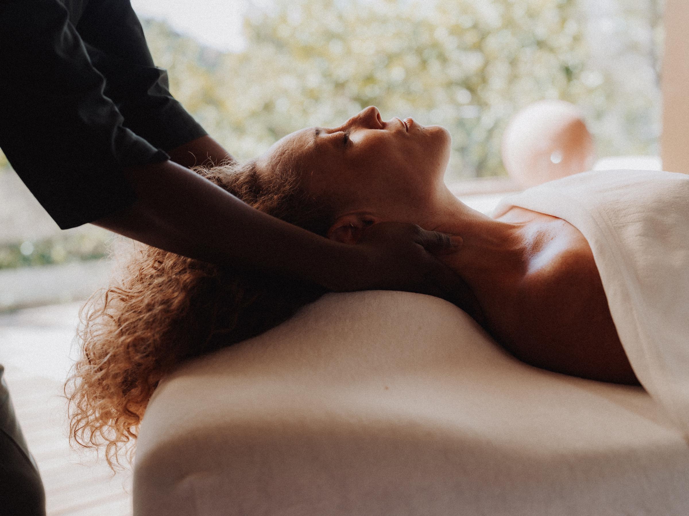 Neck massage: the practitioner's hands under the head, face relaxed