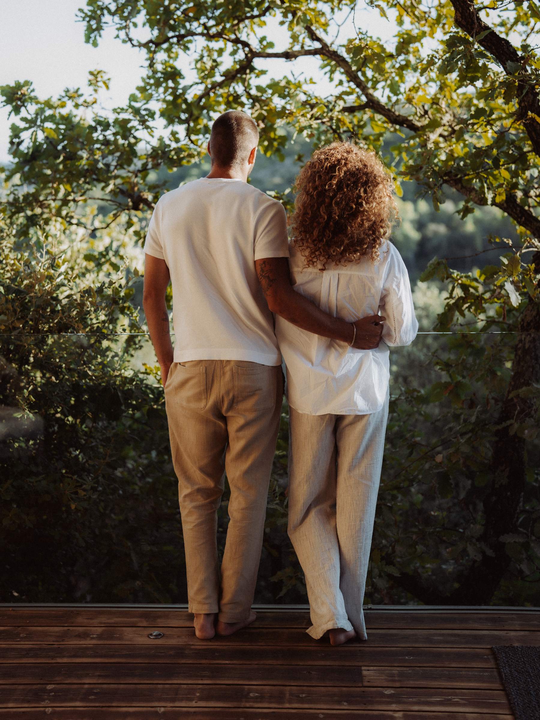 A couple from behind on the terrace at sunset, facing the hills